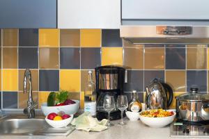 a kitchen counter with bowls of food and a sink at Aparthotel Adagio Köln City in Cologne