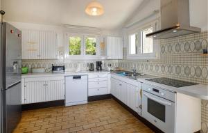 a kitchen with white cabinets and white appliances at Lovely Home In Porticcio With Wifi in Porticcio