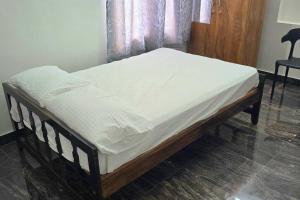 a bed with white sheets on it in a room at Entire 4 Bedroom Villa in Kannur in Edakkād