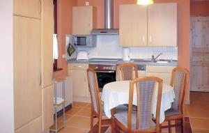 une cuisine avec une table, des chaises et une cuisinière dans l'établissement Ferienwohnung Karlshagen, à Karlshagen