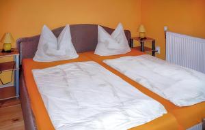 - un lit avec des draps et des oreillers blancs dans l'établissement Ferienwohnung Karlshagen, à Karlshagen