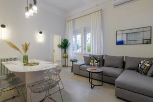 アテネにあるKoukaki Cielo Villa10 -Pvt Yard 3BR 8ppl -10min Metro Acropolisのソファとテーブルのあるリビングルーム +26枚の写真