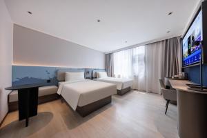 a hotel room with a bed and a flat screen tv at Atour Light Hotel Kunming Dianchi Road South Asia Style First City in Kunming +40 photos