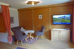 a living room with a tv and a table and chairs at Alkira in Sankt Anton am Arlberg