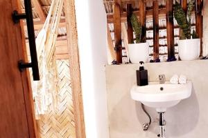ein Badezimmer mit einem Waschbecken und Topfpflanzen an der Wand in der Unterkunft Duon Baler - Seconds from Sabang beach, your peaceful escape in Baler