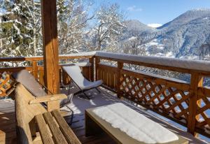 une terrasse avec un banc, une chaise et des montagnes dans l'établissement Chalet prestige Saint Gervais les Bains, à Saint-Gervais-les-Bains