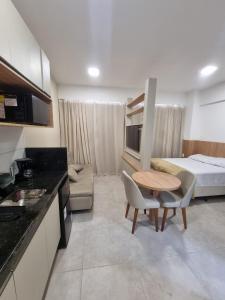 um quarto com uma cozinha, uma cama e uma mesa em Flat Central todo equipado! em Recife