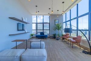 uma sala de estar com mobiliário branco e janelas grandes em Flat Central todo equipado! em Recife