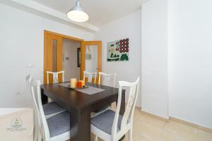 ein Esszimmer mit einem Holztisch und Stühlen in der Unterkunft Bonito apartamento cerca de playa in El Campello