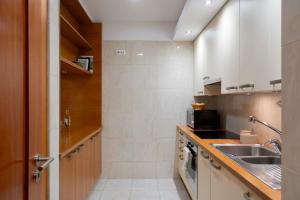 a small kitchen with a sink and a stove at Arriaga Residence I by An Island Apart in Funchal +23 photos