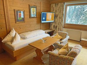 a room with a bed and a table and chairs at Alkira in Sankt Anton am Arlberg