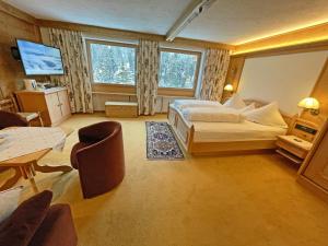 a hotel room with a bed and a table and chairs at Alkira in Sankt Anton am Arlberg