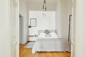 a white bedroom with a bed with white pillows at Prague Days - Old Town Square Apartments in Prague