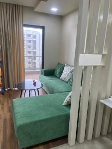 a living room with a green couch and a table at 3 BHK exclusive suite in Nashik