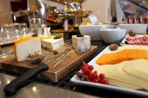 a counter with cheese and other foods on a cutting board at Gresham Belson Hotel Brussels in Brussels