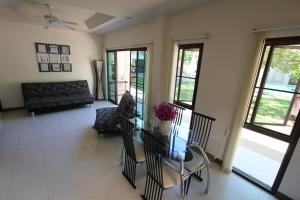 a living room with a table and a couch at Babylon Pool Villas in Nai Harn Beach