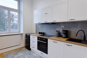 a kitchen with white cabinets and a sink and a window at Apartament na Granicy 5 in Cieszyn
