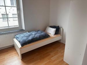un lit assis dans une pièce à côté d'une fenêtre dans l'établissement Ferienwohnung im Herzen von Betzdorf, à Betzdorf