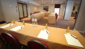 a conference room with a long table with bottles and chairs at Gresham Belson Hotel Brussels in Brussels