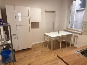 une cuisine avec une table et un réfrigérateur blanc dans l'établissement Ferienwohnung im Herzen von Betzdorf, à Betzdorf 2 autres photos