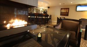 a lobby with a fireplace and a bar at Gresham Belson Hotel Brussels in Brussels