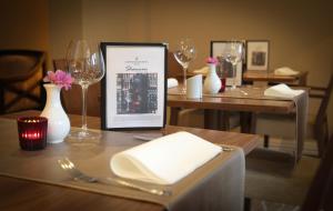 a table with wine glasses and a menu on it at Gresham Belson Hotel Brussels in Brussels