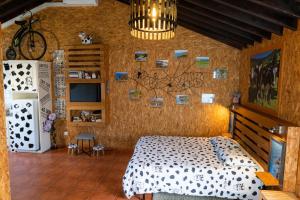 a bedroom with a bed and a wall with pictures on it at Azores Cow House in Calhetas