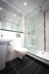 a bathroom with a shower and a toilet and a sink at Gresham Belson Hotel Brussels in Brussels