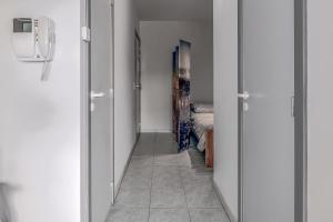 einen Flur mit weißen Wänden und ein Zimmer mit einem Bett in der Unterkunft Galathea B0303 in Oostduinkerke + 10 Fotos