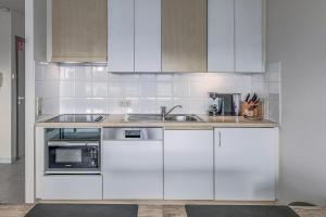 eine weiße Küche mit weißen Schränken und einer Spüle in der Unterkunft Galathea B0303 in Oostduinkerke