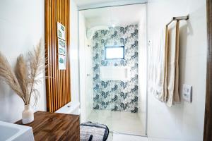 a bathroom with a toilet and a glass door at Cabana Perfeita a 800m da Praia - Lareira externa, Quintal Amplo, Pet Friendly, Ar condicionado, Netflix e Conforto completo in Imbituba +63 photos