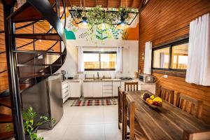 a kitchen with a wooden ceiling and a wooden table at Cabana Perfeita a 800m da Praia - Lareira externa, Quintal Amplo, Pet Friendly, Ar condicionado, Netflix e Conforto completo in Imbituba
