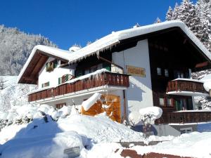 a building covered in snow with snow at Allgäu Sonne in Oberstdorf