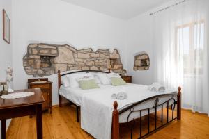 a bedroom with a bed with a stone wall at House Bruna in Kršan +51 photos