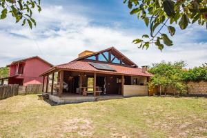 a home with a red house with a yard at Cabana Perfeita a 800m da Praia - Lareira externa, Quintal Amplo, Pet Friendly, Ar condicionado, Netflix e Conforto completo in Imbituba