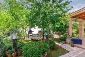 un giardino con fiori e alberi in un cortile di Apartments Katrina a Rakalj