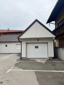 a building with two garage doors in a parking lot at Relax & Lux apartman in Bijeljina