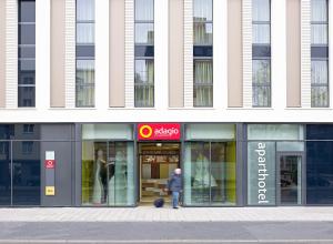 a man walking in front of a building at Aparthotel Adagio Köln City in Cologne