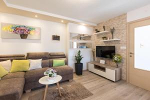 Una sala de estar con un sofá y un televisor. en House Mari, en Punat