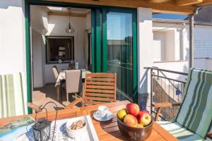 Una mesa con un bol de fruta en un balcón. en House Mari, en Punat