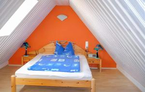 une chambre avec un lit avec un mur orange dans l'établissement Ferienwohnung Karlshagen, à Karlshagen
