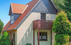 une maison avec un balcon au-dessus dans l'établissement Ferienwohnung Karlshagen, à Karlshagen 1 autre photo