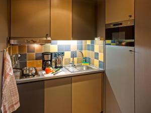 a kitchen with a sink and a refrigerator at Aparthotel Adagio Köln City in Cologne