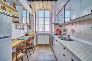 a kitchen with a sink and a counter with chairs at Apartments Old Sailor s House in Mali Lošinj