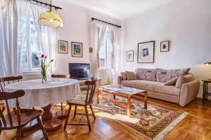 a living room with a table and a couch at Apartments Old Sailor s House in Mali Lošinj