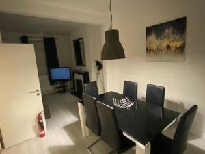 a dining room with a black table and chairs at Nansen house next to royal hospital in Belfast +9 photos