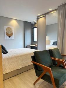 um quarto com uma cama e uma cadeira verde em Novo e Aconchegante Caminhe ao Allianz Parque em São Paulo mais 72 fotografias