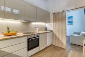 a kitchen with white cabinets and a counter top at stefanos house in Aliki +6 photos