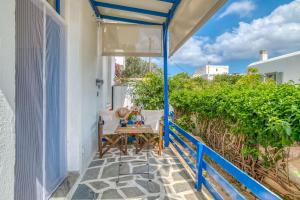 a patio with a table and a blue railing at stefanos house in Aliki