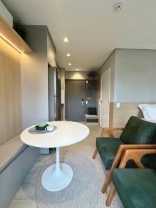 uma sala de estar com uma mesa e um sofá em Novo e Aconchegante Caminhe ao Allianz Parque em São Paulo